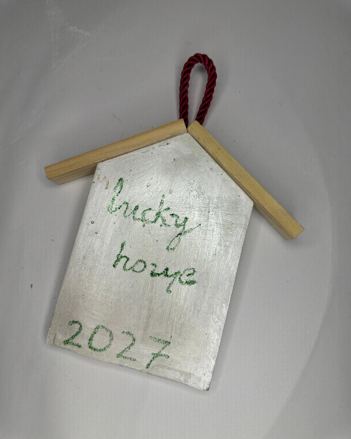 Μπροστινή όψη λευκού κρεμαστού γουριού Lucky Home 2027 με φυσικές ξύλινες λεπτομέρειες