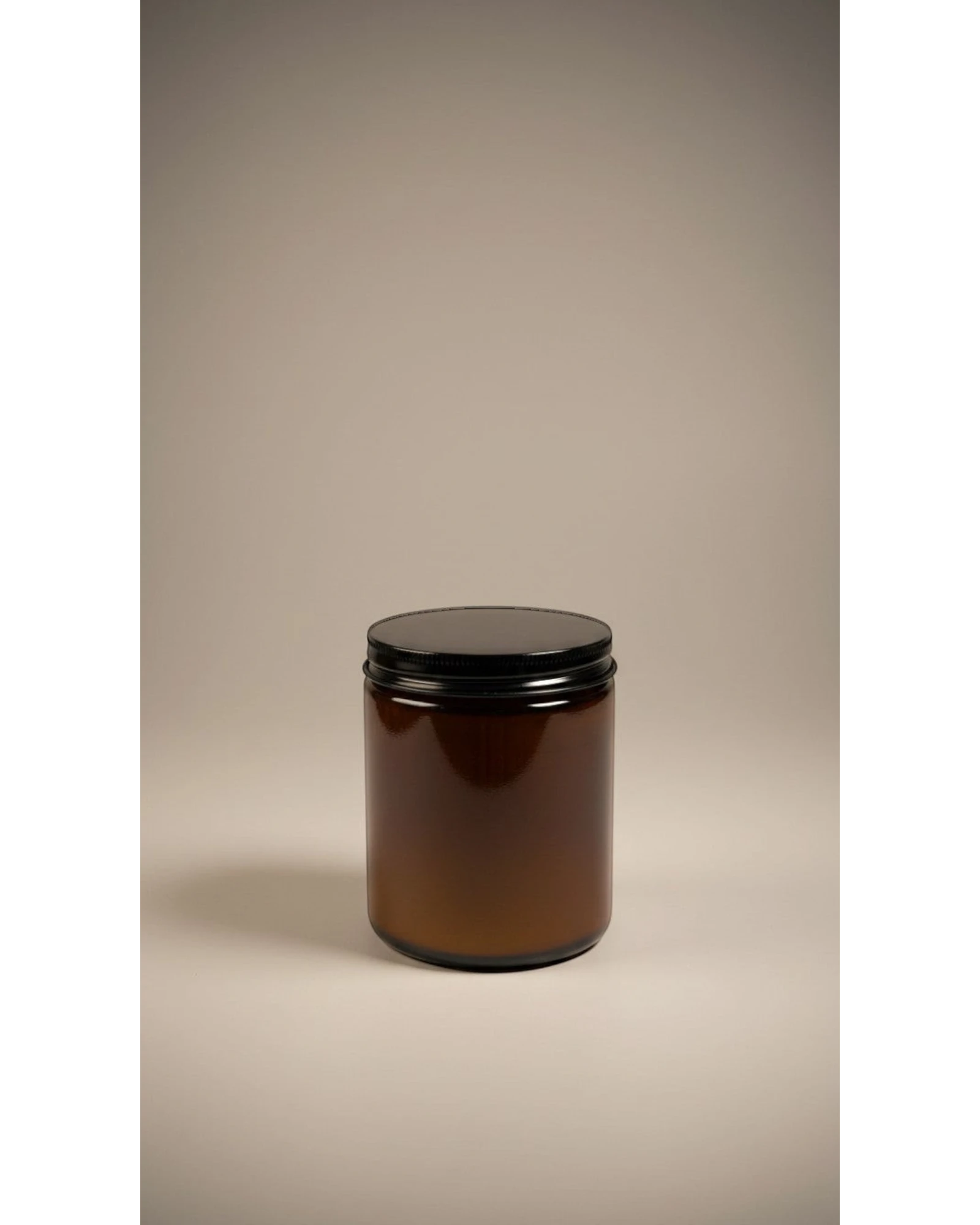 ELAIOPHOS amber glass candle with black lid, featuring shimmering gold flecks in wax for a luxurious ambiance.