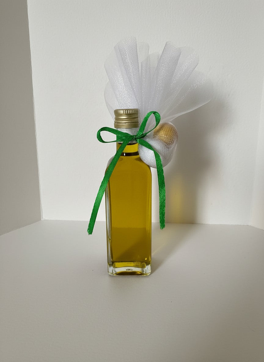 ELAIOPHOS miniature glass bottle of golden olive oil with green ribbon and white tulle decoration.