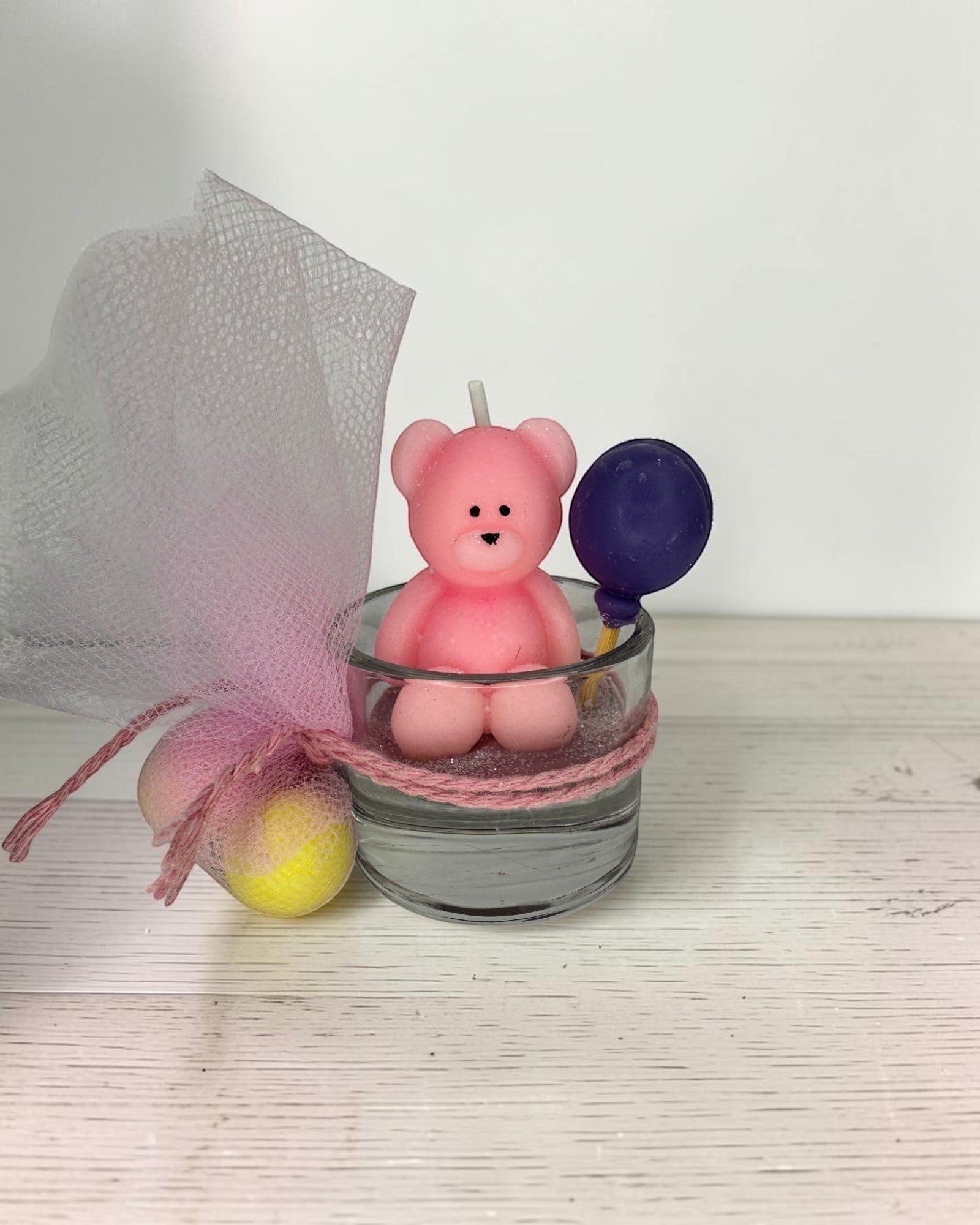 ELAIOPHOS pink teddy bear soy wax candle with purple balloon accent in glass jar, decorated with tulle and sugared almonds.