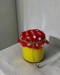 ELAIOPHOS yellow scented jar candle with red polka dot fabric lid tied with twine. Modern aesthetic, cozy ambiance.