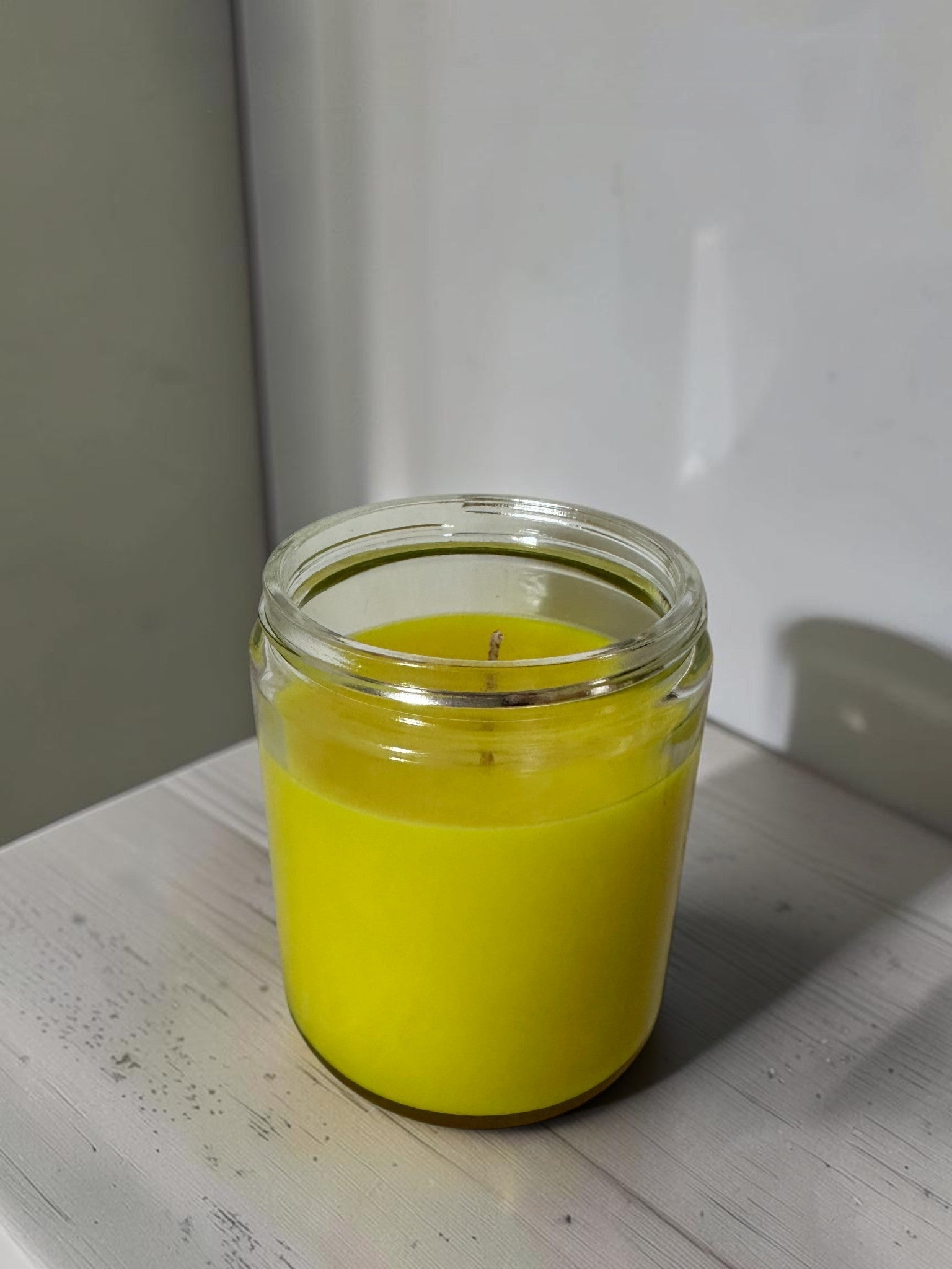 ELAIOPHOS bright yellow scented candle in a clear glass jar, perfect for home decor and creating a cozy ambiance.