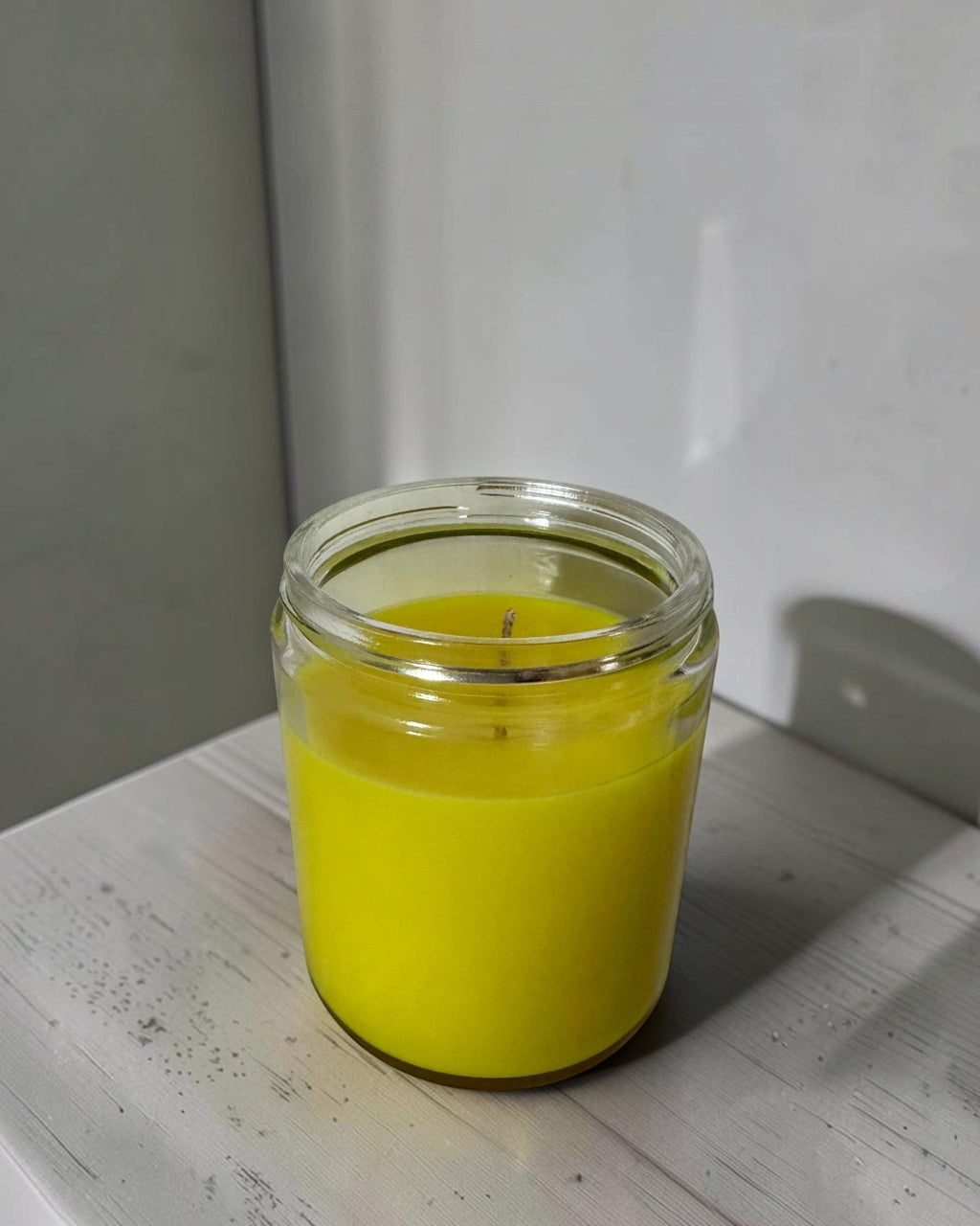 ELAIOPHOS bright yellow scented candle in a clear glass jar, perfect for home decor and creating a cozy ambiance.